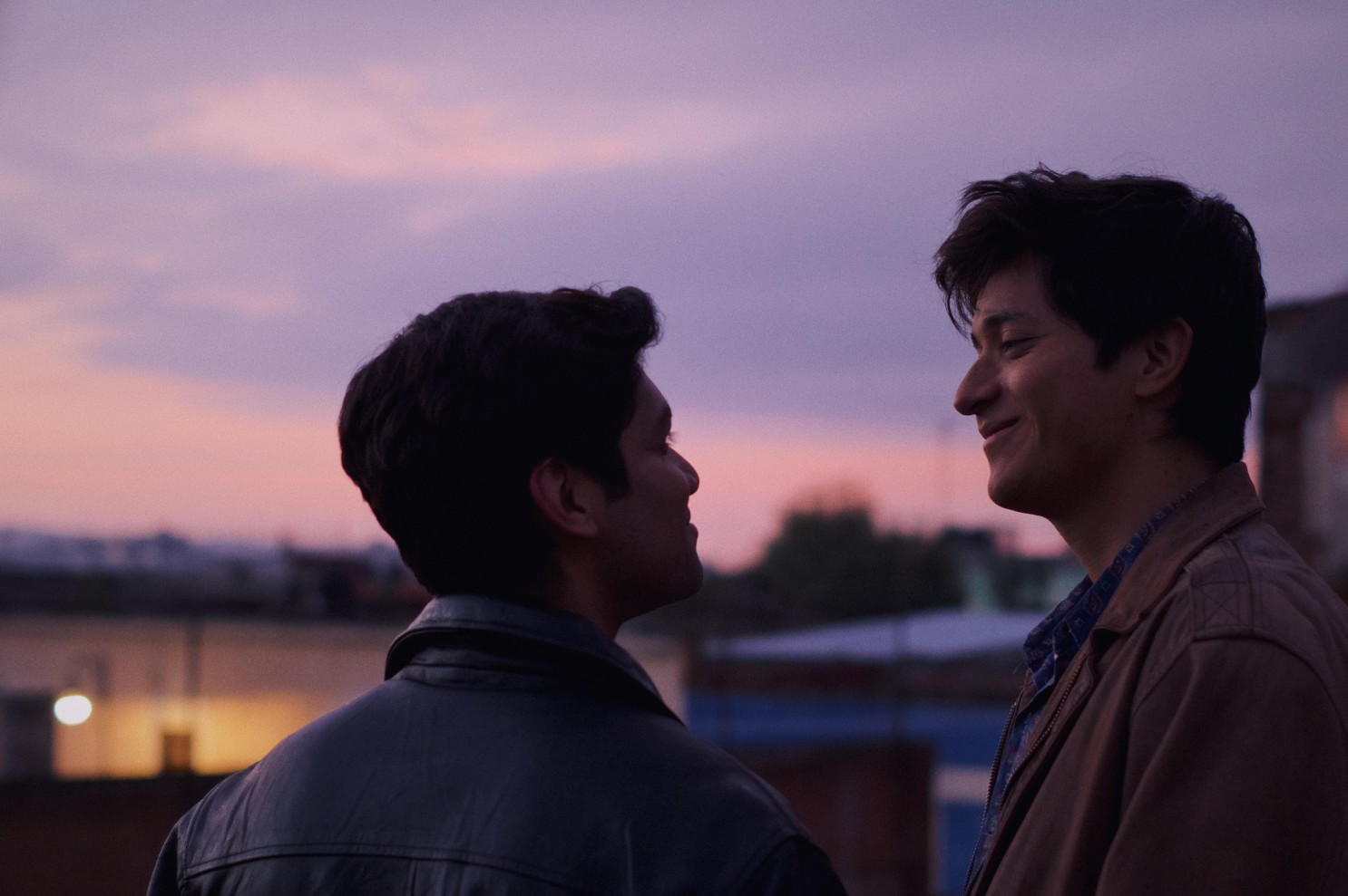 Two men look at each other with love at sunrise.